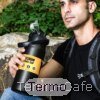 Hombre con mochila sosteniendo botella térmica TrailForce negra mate de 1500 ml en entorno natural, ideal para uso outdoor o aventura