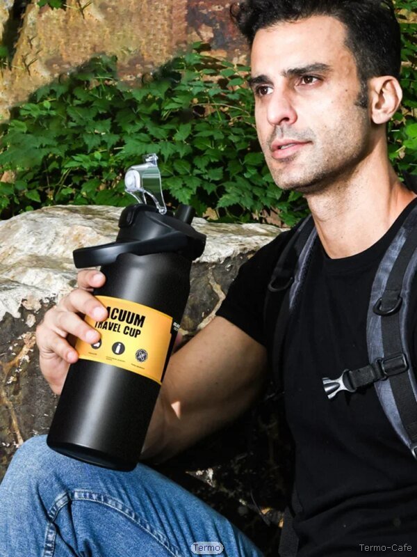 Hombre con mochila sosteniendo botella térmica TrailForce negra mate de 1500 ml en entorno natural, ideal para uso outdoor o aventura